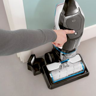 hand pointing on vacuum cleaner and white floor