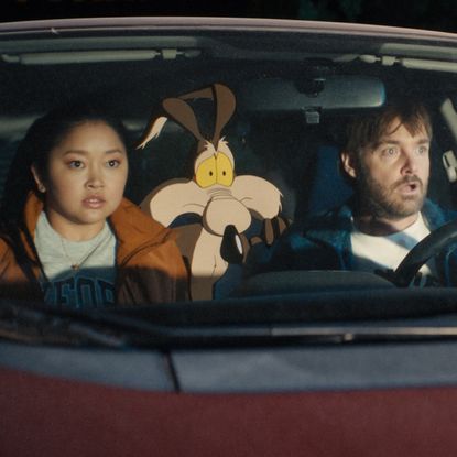 lana condor an animated wile e coyote and will forte ride in a car together in a still from coyote vs acme