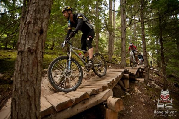 Racers flow over a bridge on the final stage of the BC Bike Race