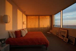 timber bedroom interior with large window in dusk light