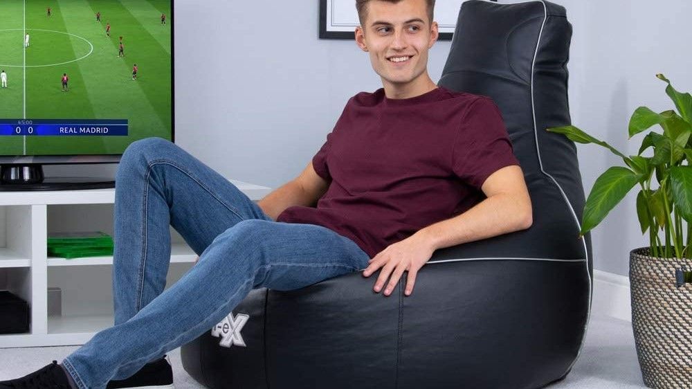 A marketing image showing someone sat in the i-eX gaming chair bean bag
