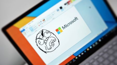 An angry reaction meme made in Microsoft Paint next to the Microsoft logo.