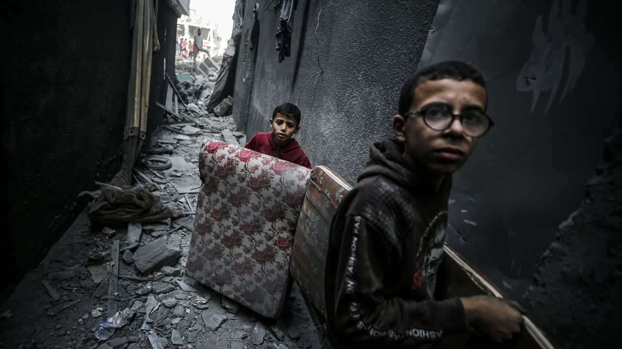 Children carry usable items after the strike on the Jabalia refugee camp in Gaza City on 1 November, 2023