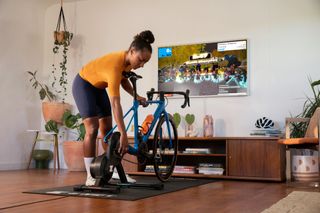 Woman setting up a Zwift Hub turbo trainer at home