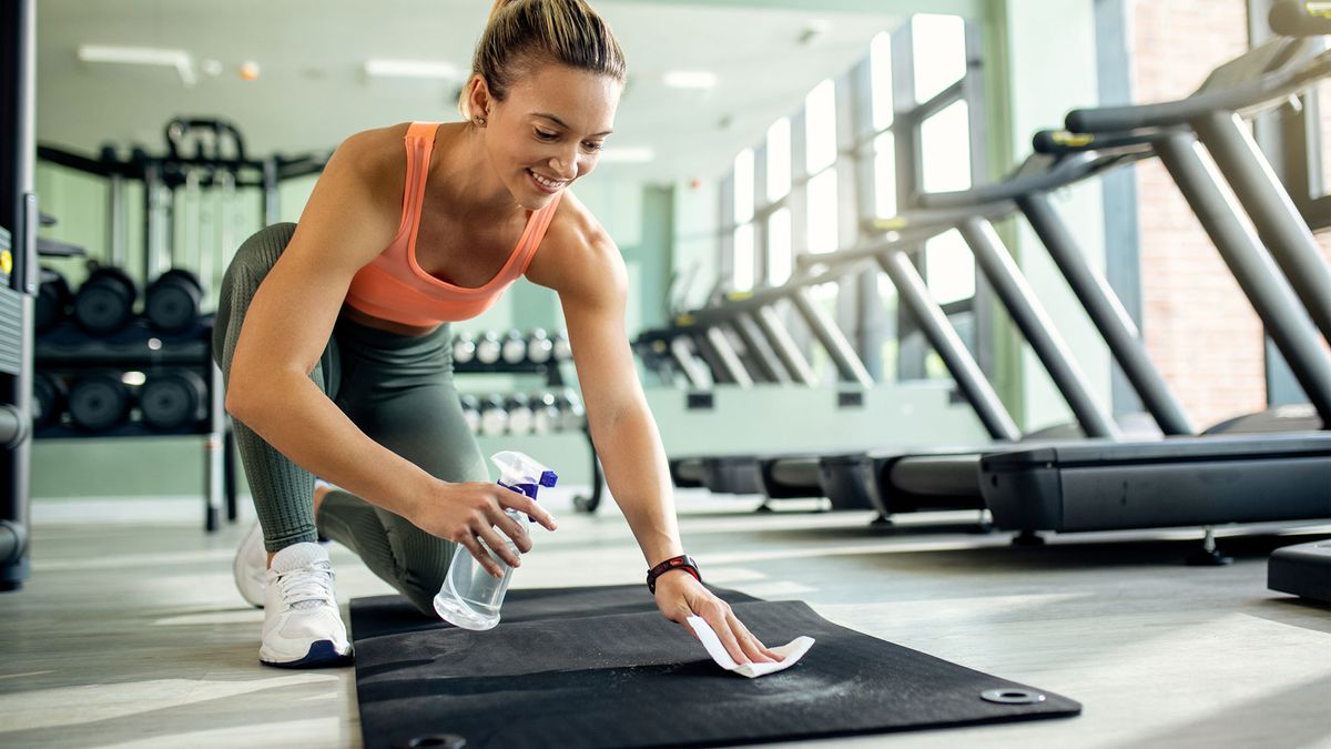 How to clean a yoga mat: image shows woman cleaning a yoga mat