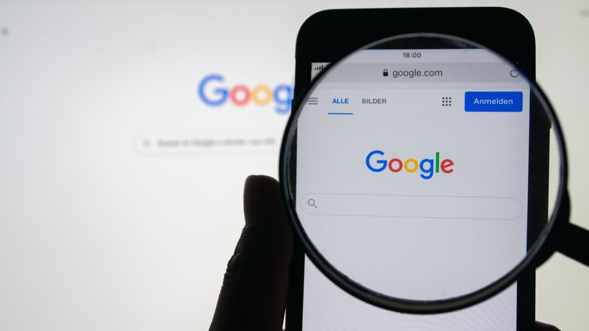 A silhouette of a person holding a magnifying glass over the Google home screen on iPhone 