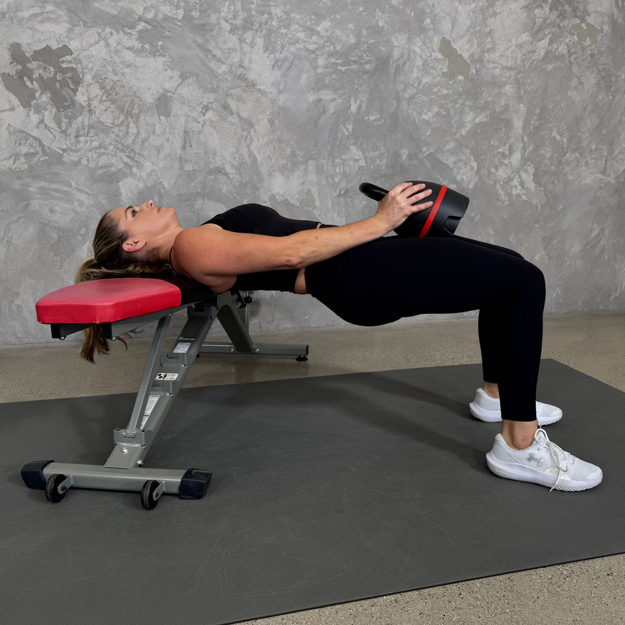 Woman in blue sportswear exercises with kettlebell