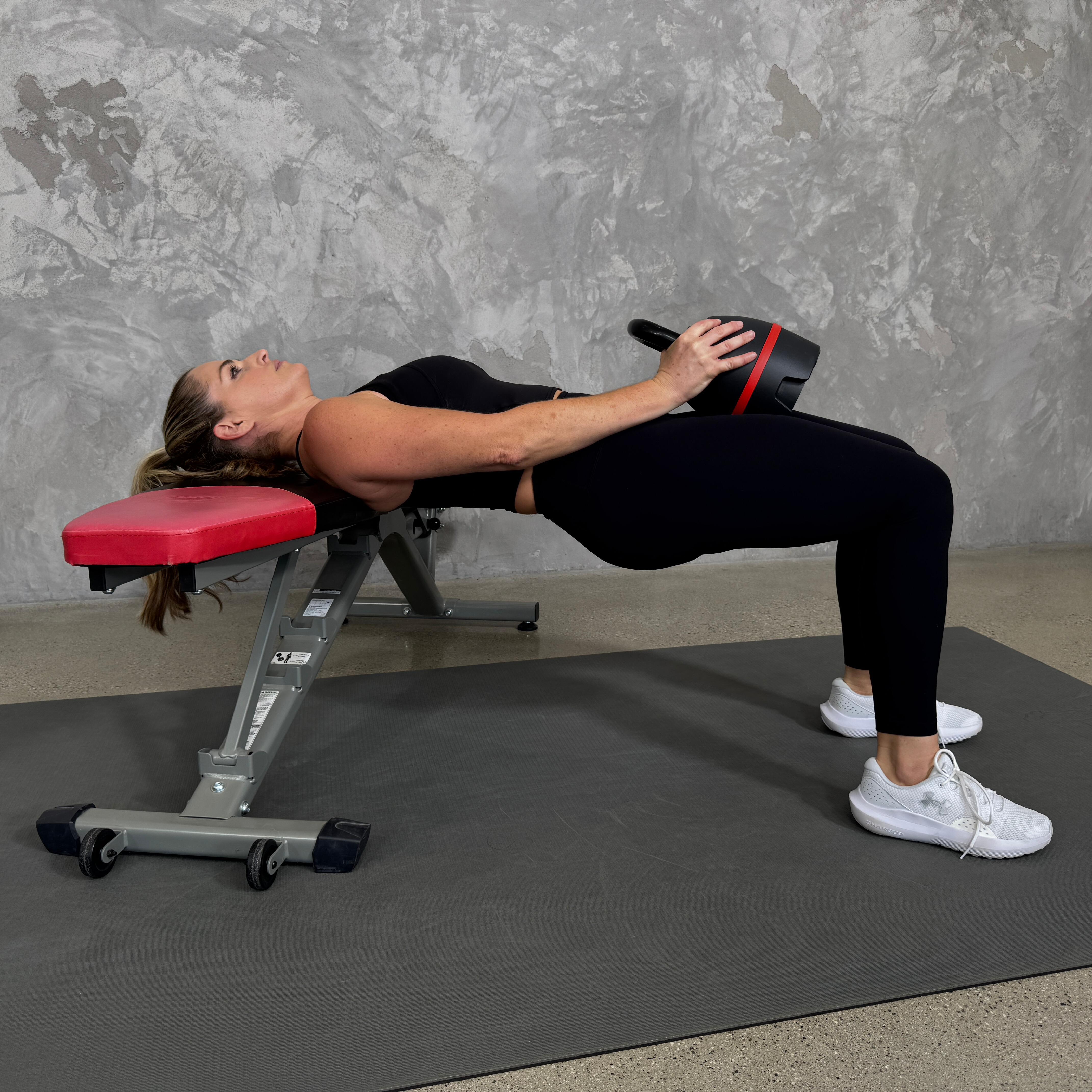 Woman in blue sportswear exercises with kettlebell