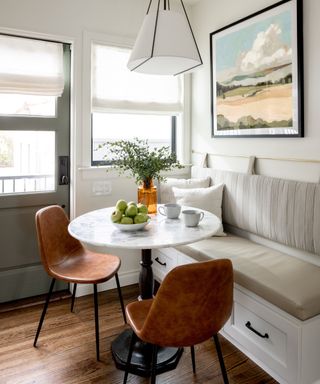 Breakfast nook in the corner of a kitchen with banquette seating and a round table