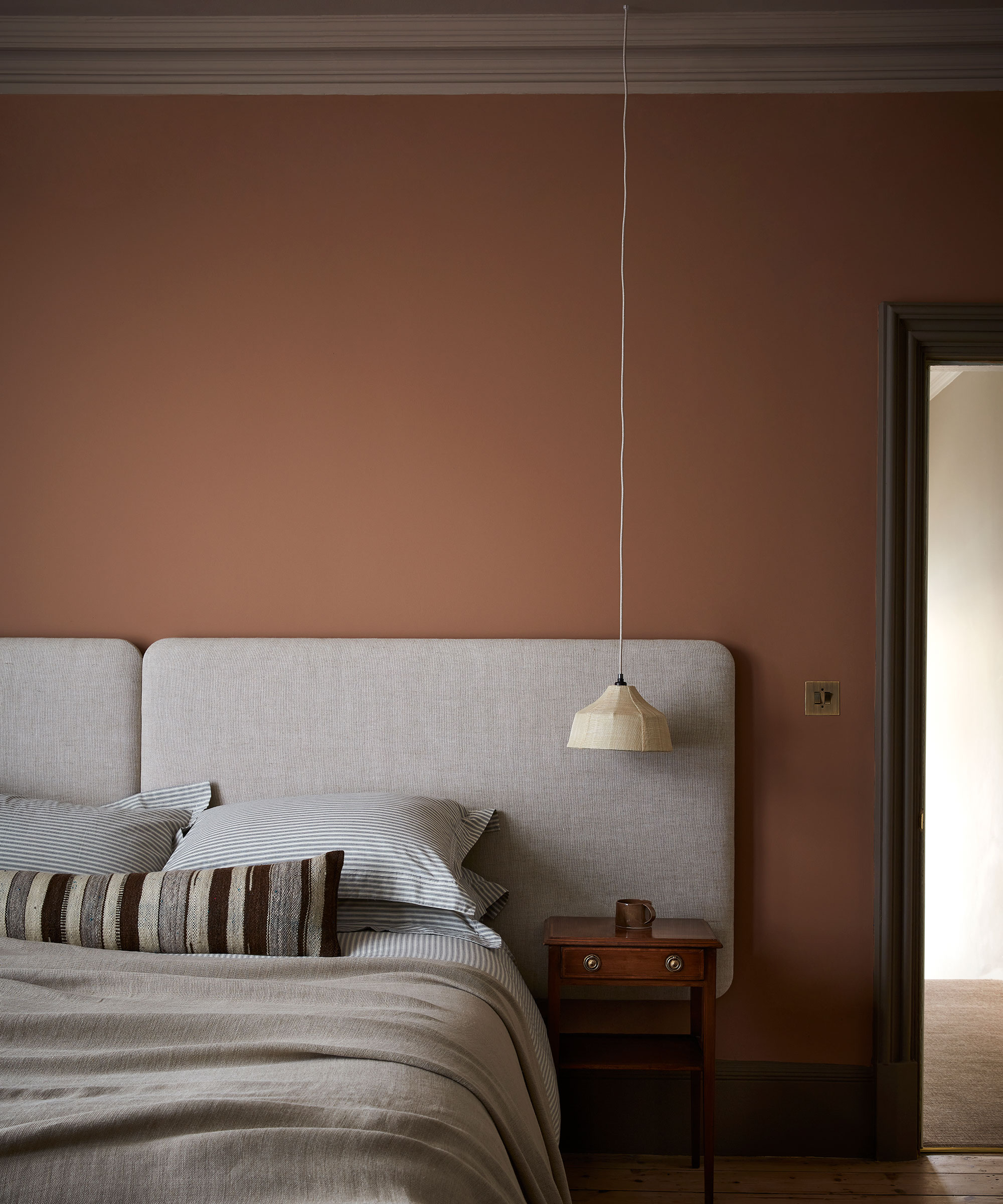 pink master bedroom with grey upholstered headboard