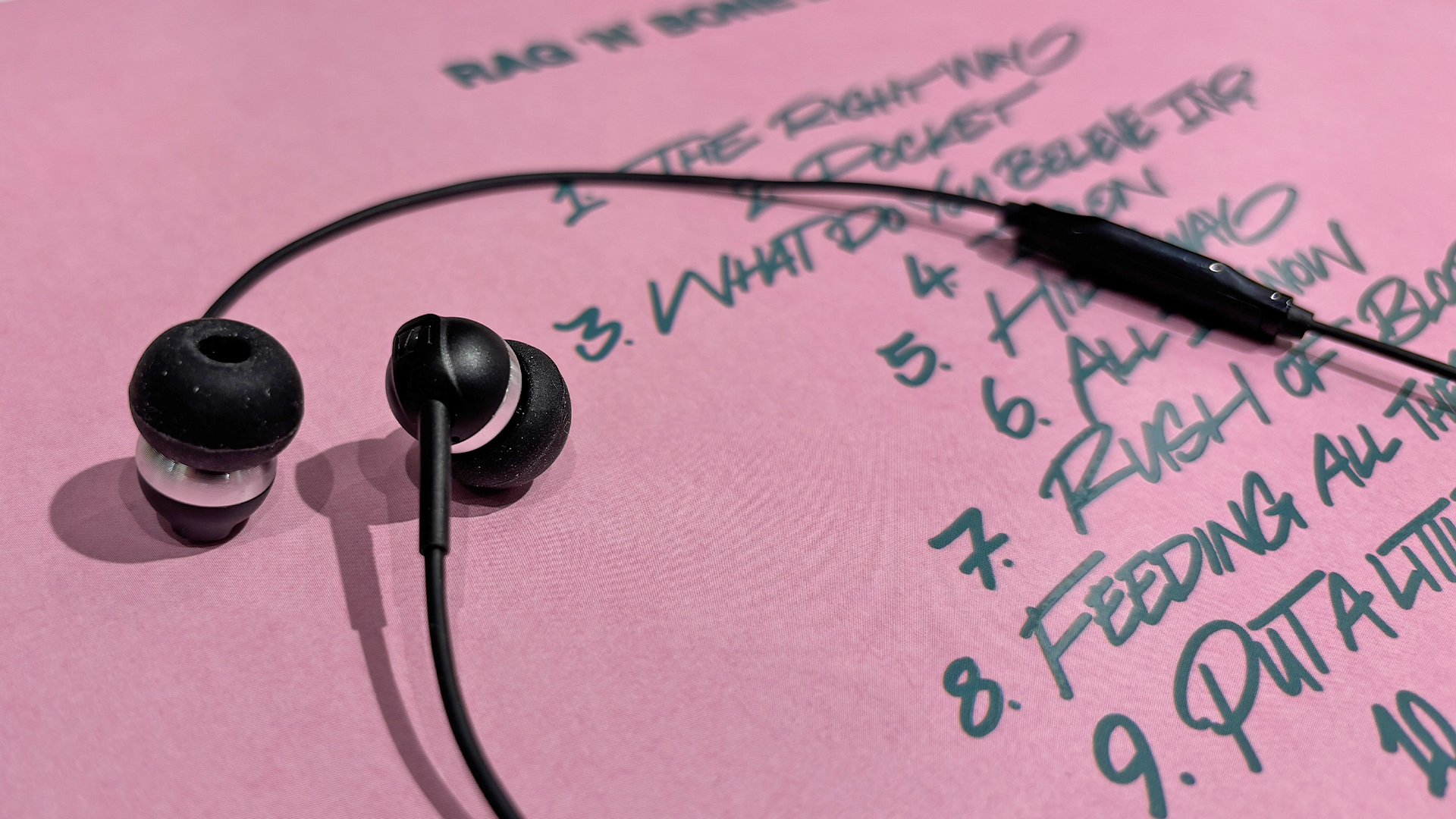 Sennheiser CX 80U wired earbuds on pink album cover