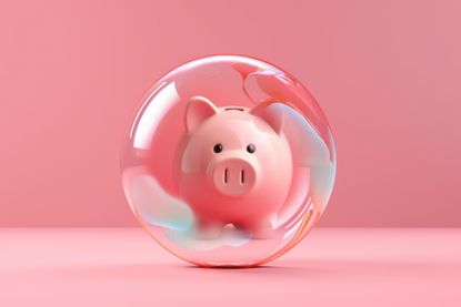 Piggy bank inside a glass ball on pink background