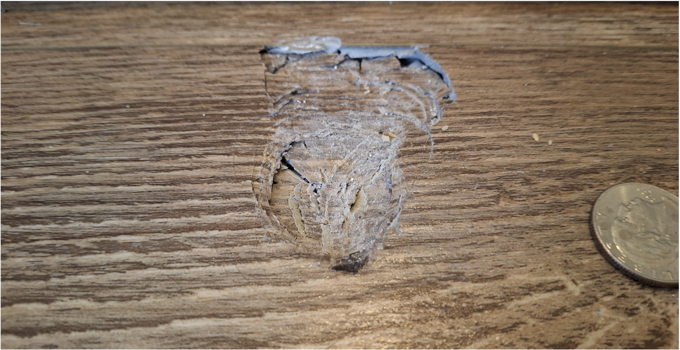 A picture of a large dent in a wooden floor created by a meteorite impact.