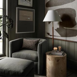 A gray armchair and wooden circular side table