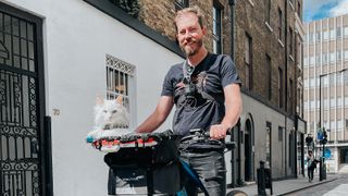 Man on bike with cat in front basket