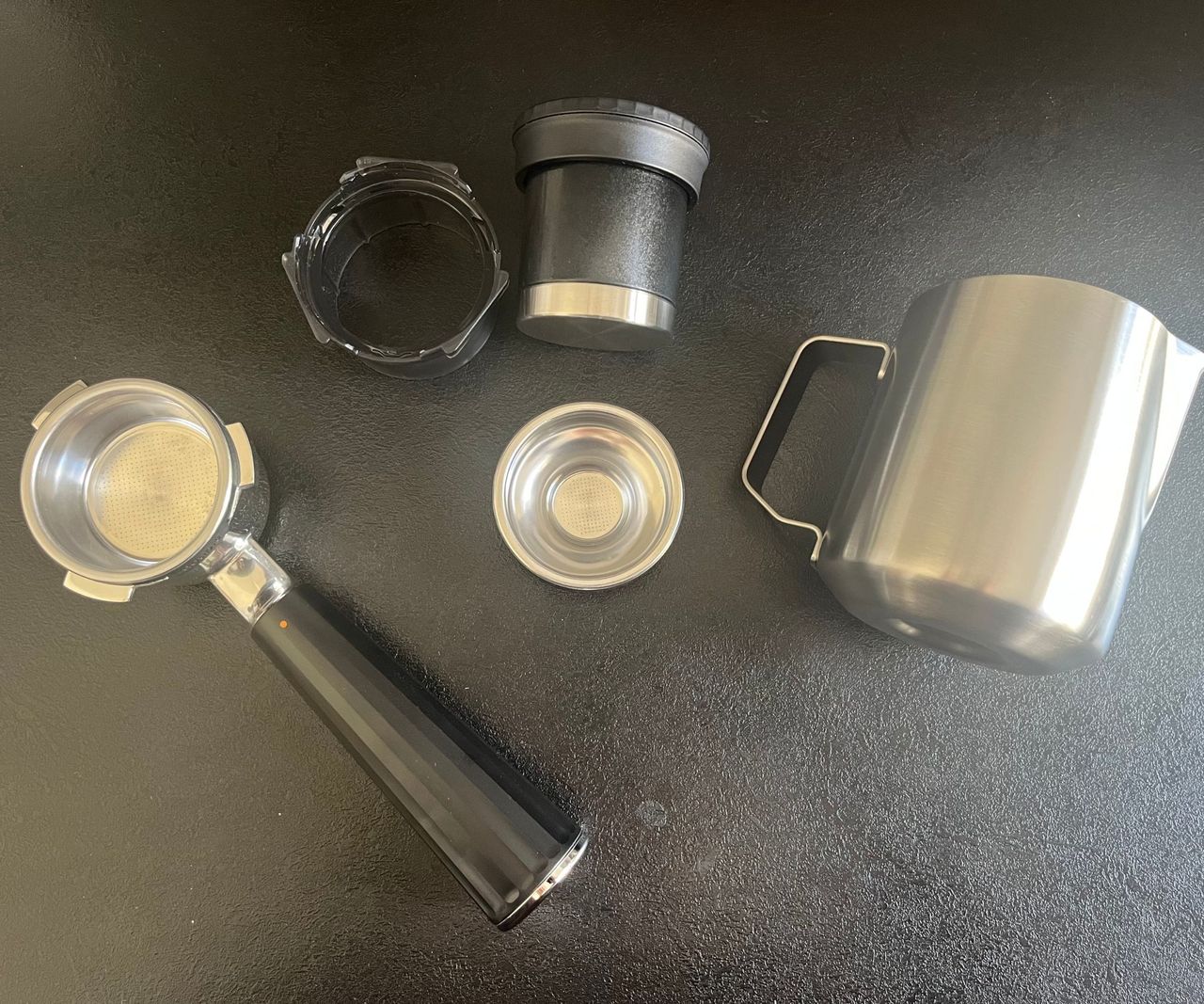 The accessories that came with the ninja luxe caf&eacute; mini espresso machine - including a milk jug, portafilter, single shot filter, funnel, and tamper.