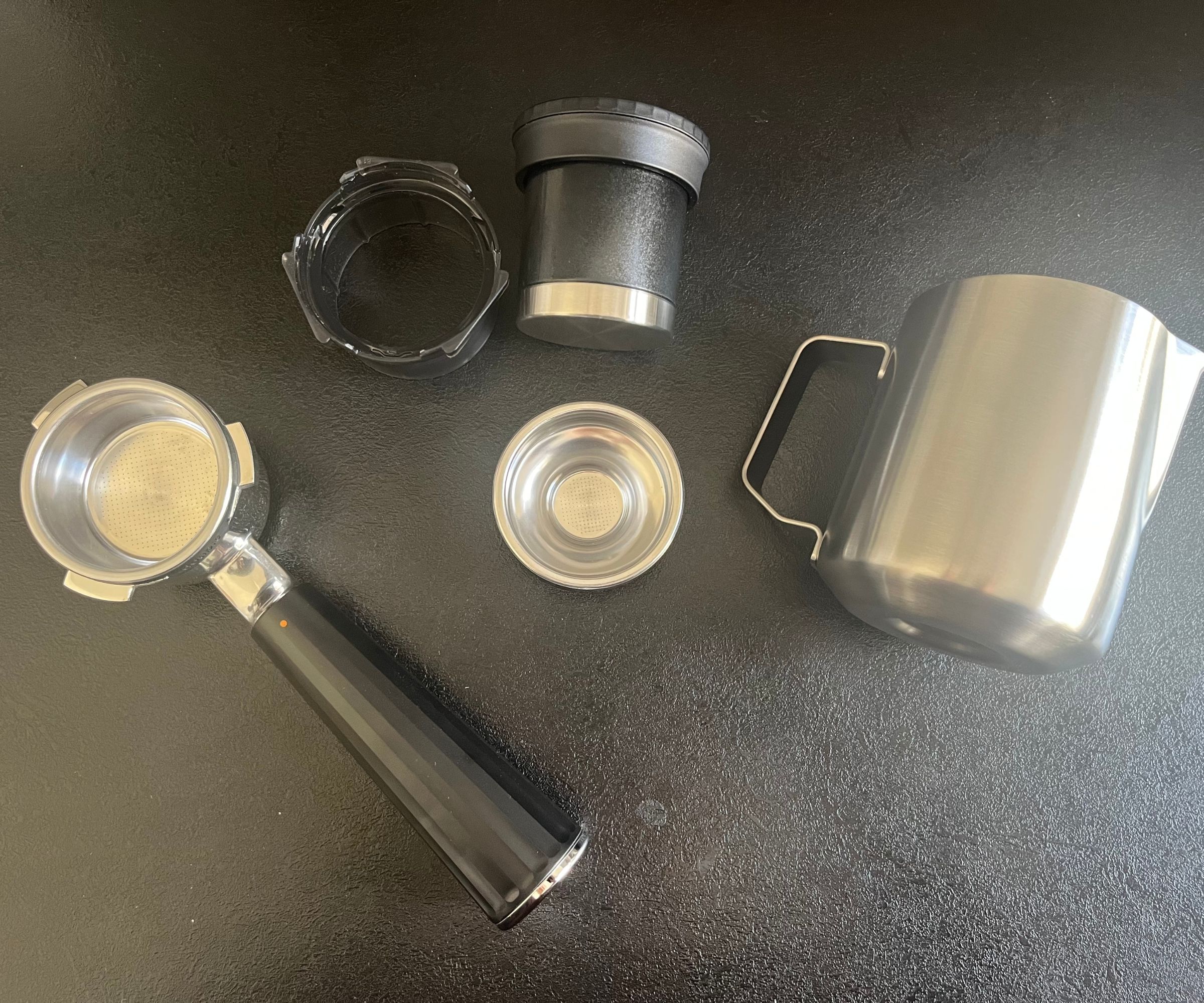 The accessories that came with the ninja luxe café mini espresso machine - including a milk jug, portafilter, single shot filter, funnel, and tamper.