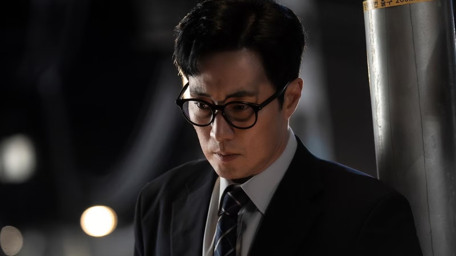 A man in a suit and glasses (actor So Ji-sub) in a still from the Korean drama 'Agent Kim Reactivated.'