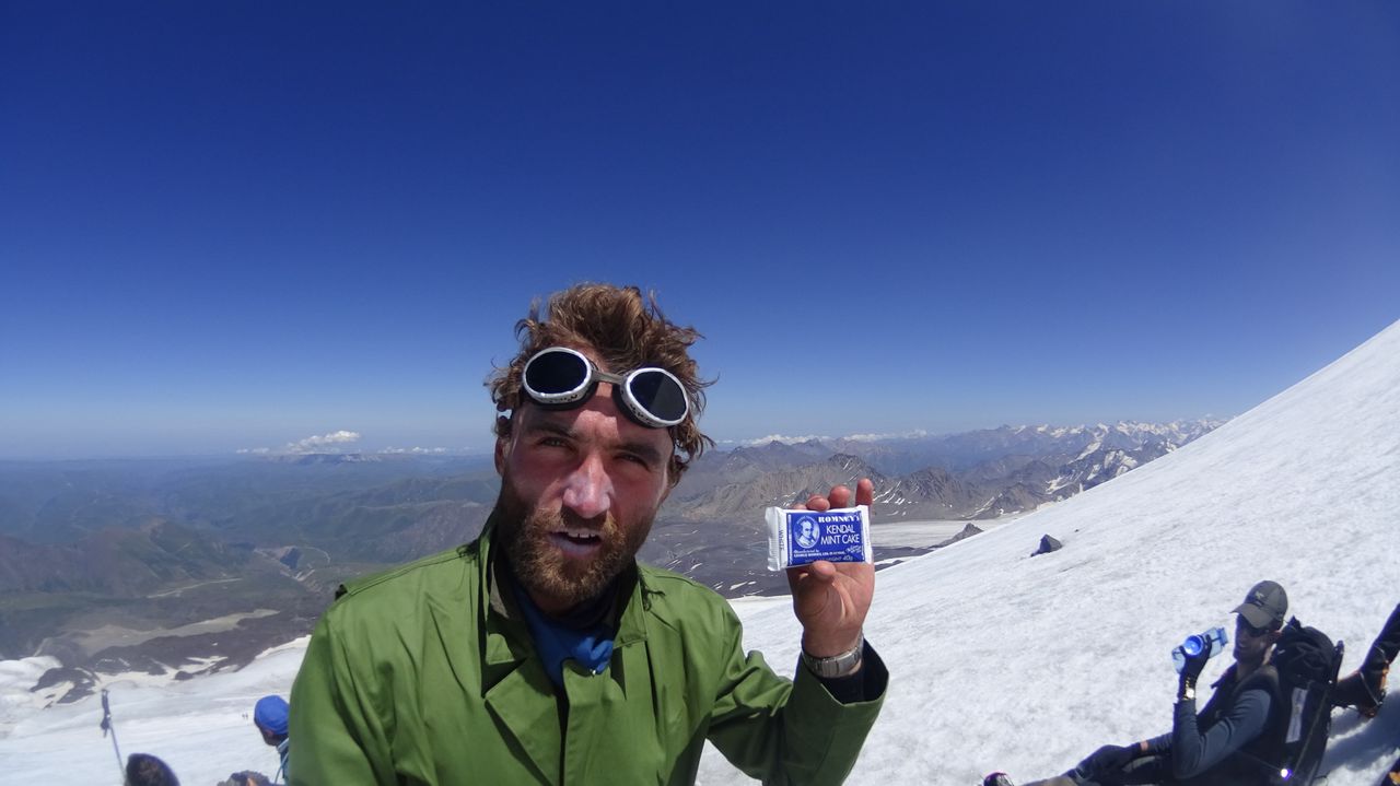 Men eating cake on top of a Russian mountain