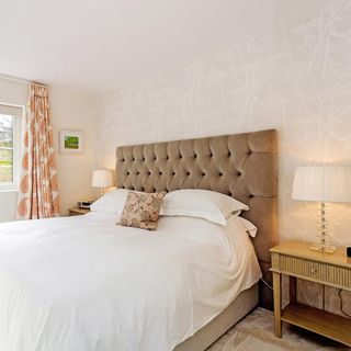 bedroom with white wall cushion and white table lamp