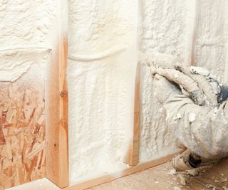 Someone spraying a woodchip wool with spray insulation