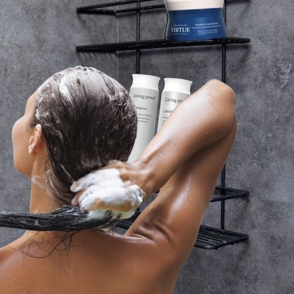 woman with fine hair washing her hair in the shower next to products