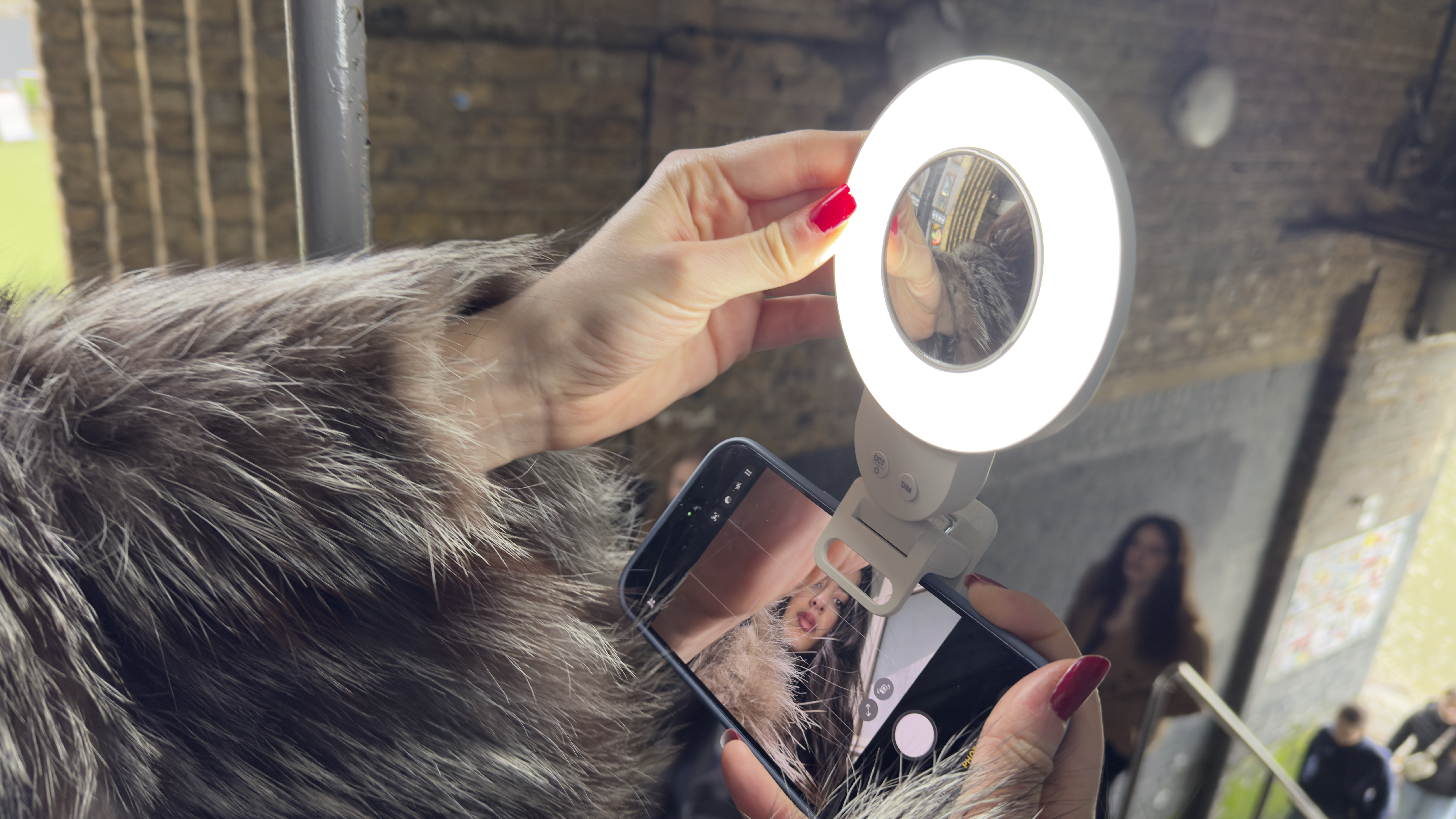 Shot of the model&amp;rsquo;s manicured fingers adjusting the angle of the ring light via its hinge.