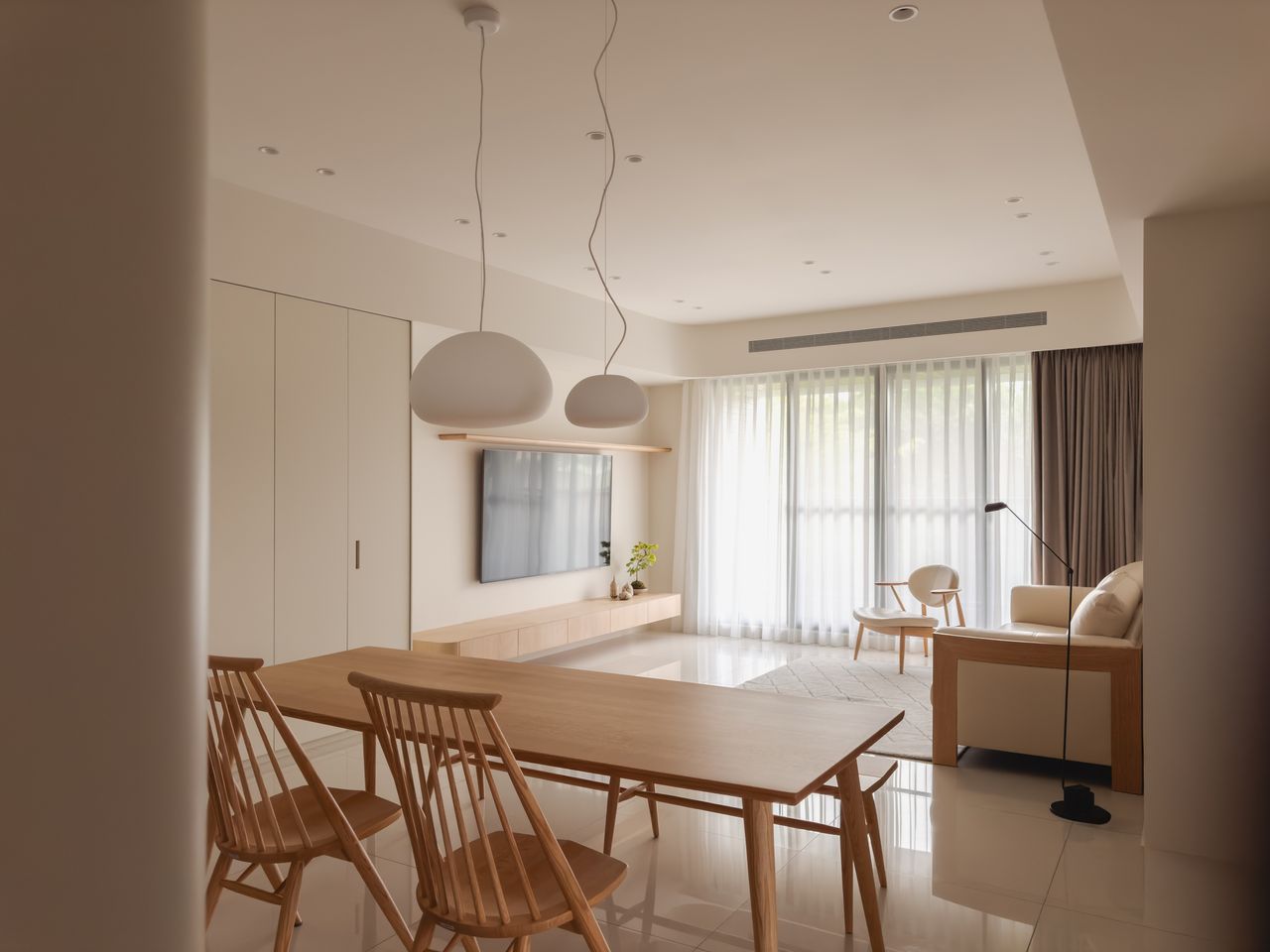 A small living room with muted interiors, a seating facing the TV
