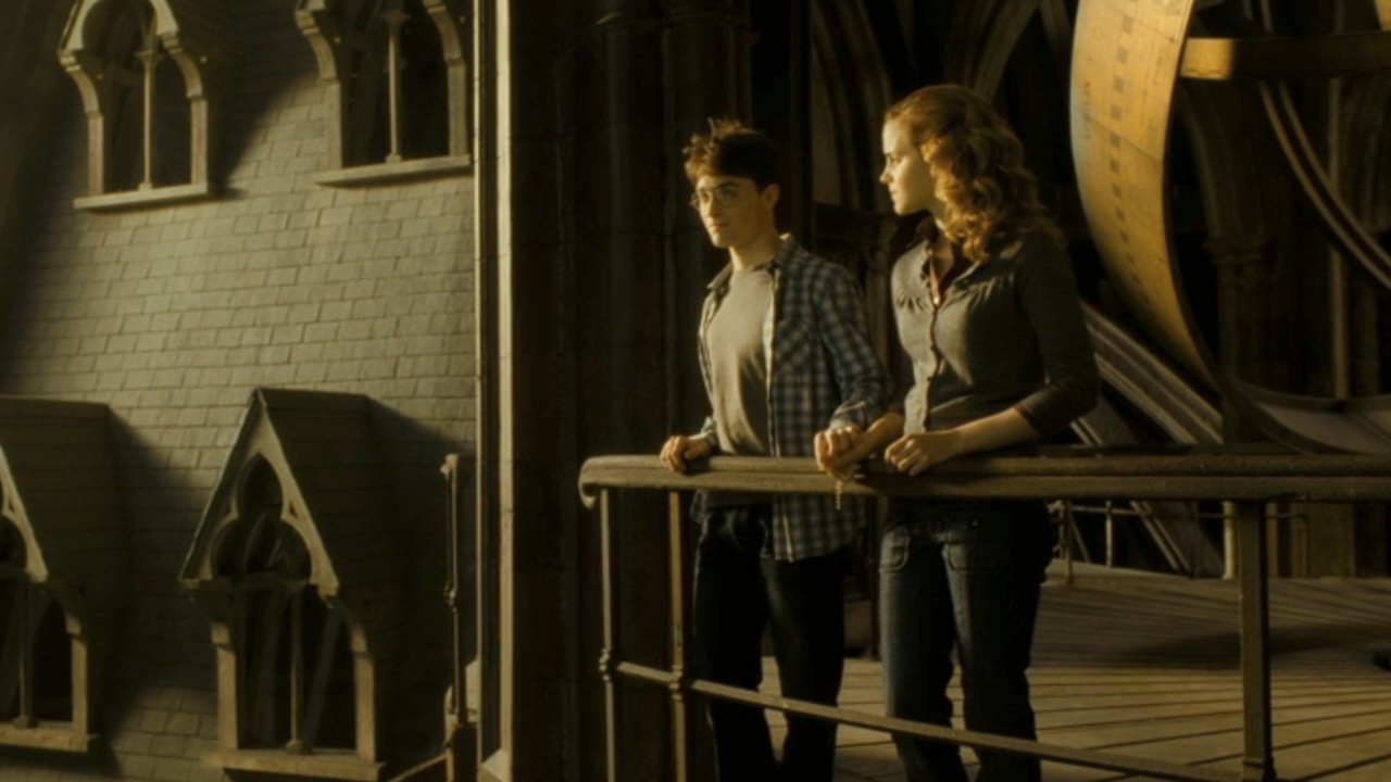 Harry and Hermione standing together on a balcony in Harry Potter and the Half-Blood Prince