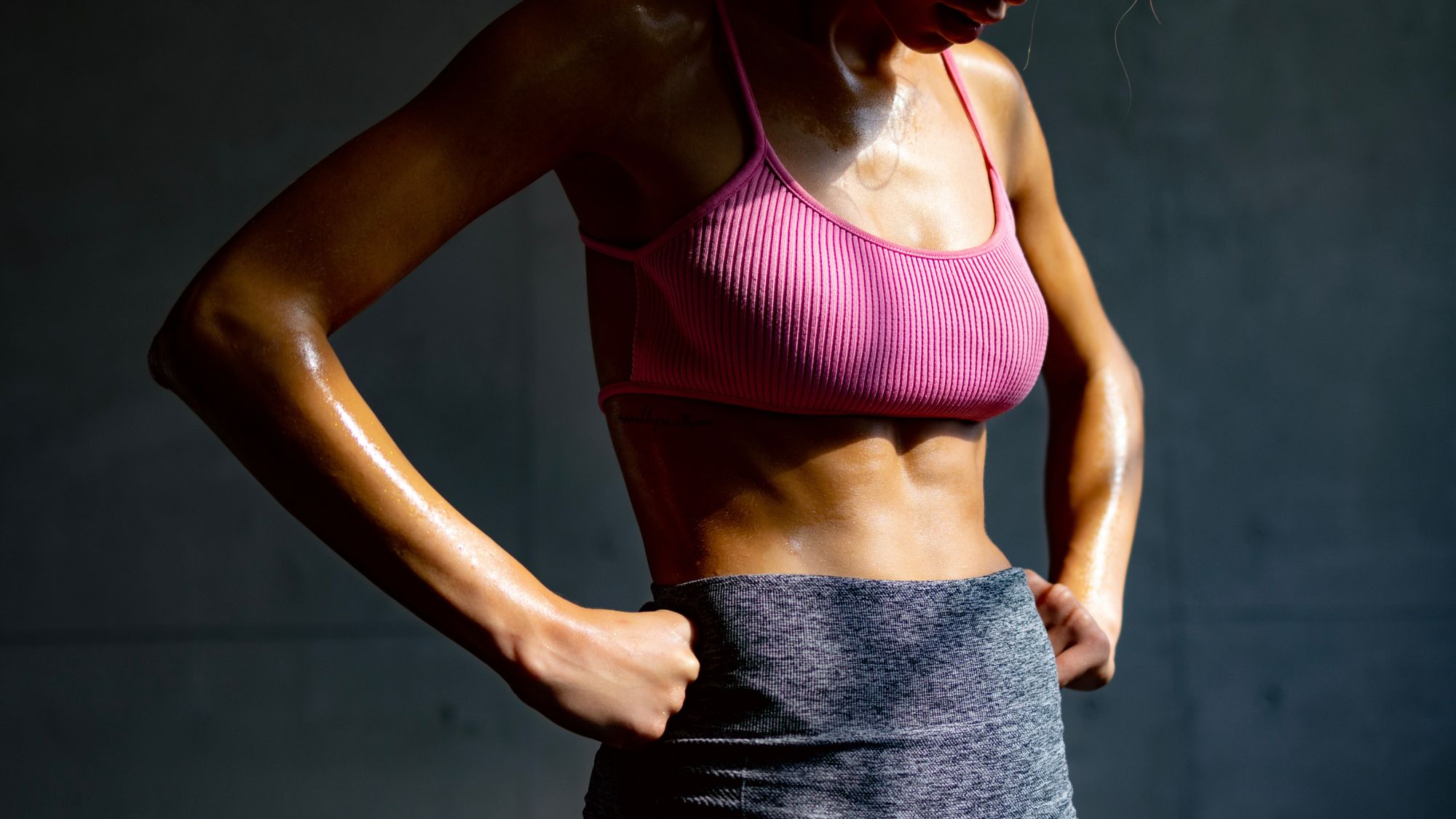 A woman doing advanced standing core exercises in a gym