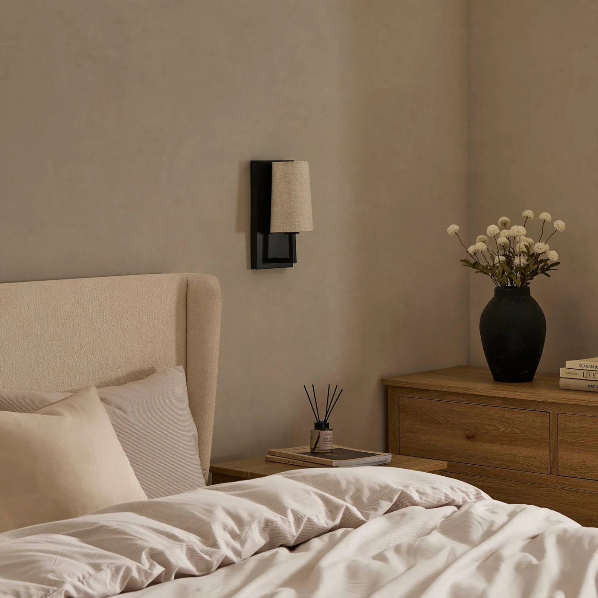Black rechargeable lamp with linen-effect shade beside beige bed frame with wooden bedside and chest of drawers