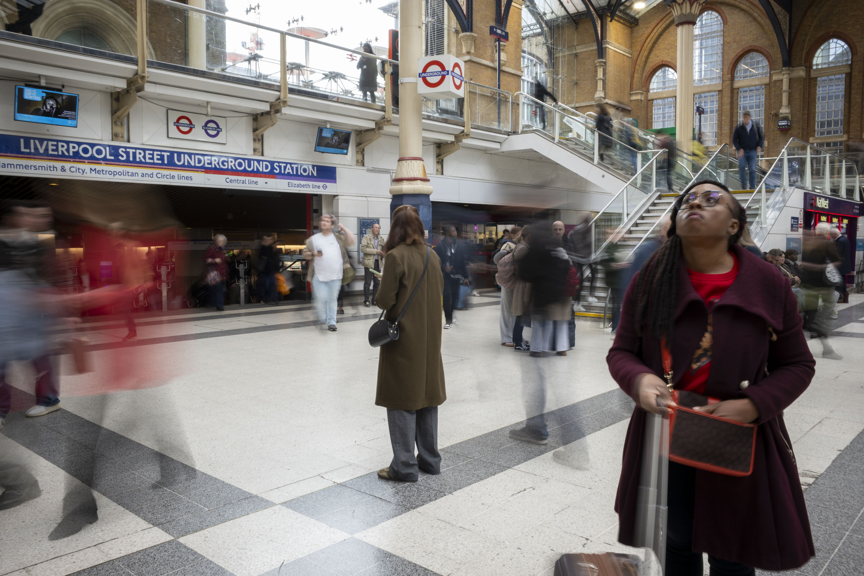 Ricoh GR IV sample gallery: commuters in a busy London train station, those moving are blurred