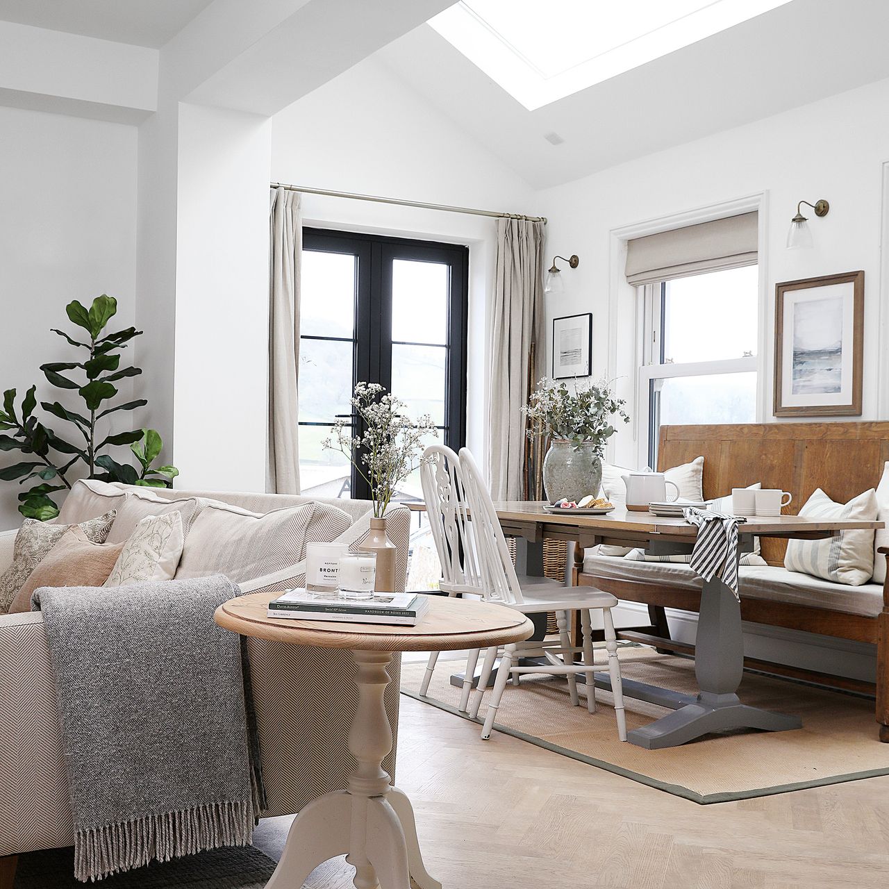 extension with white walls black framed patio doors with dining and living area in a kitchen diner
