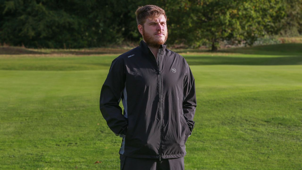 A golfer wears a Puma DRYLBL Waterproof Golf Rain Jacket