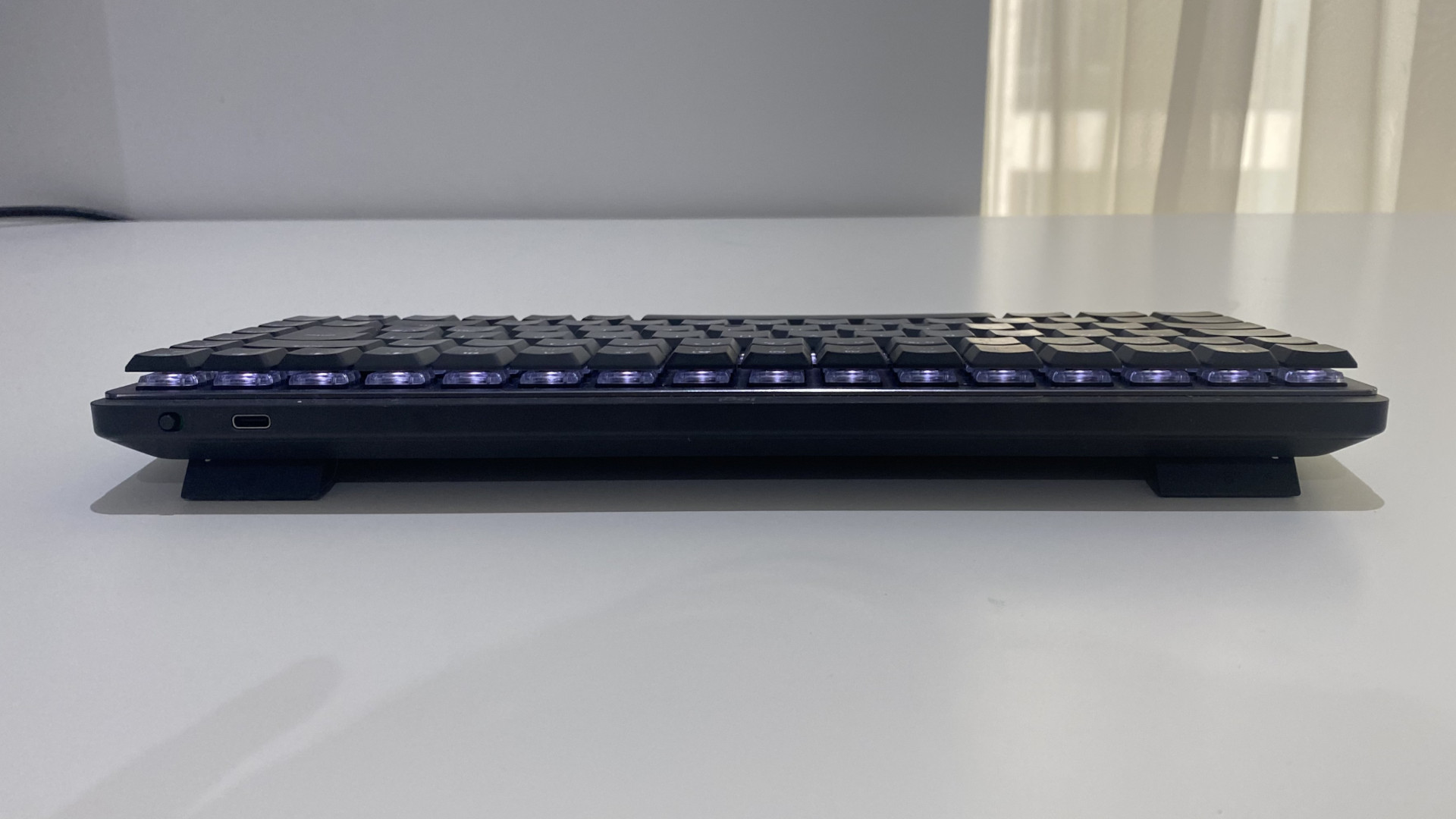 O teclado sem fio Logitech MX Mechanical Mini em uma mesa branca