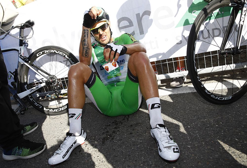 Sonny Colbrelli sits on the pavement after winning Coppa Sabatini