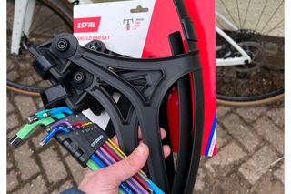 A set of rainbow coloured allen keys and the Zéfal SHIELD G50 Gravel mudguards in their packet held up prior to being fitted to a bike