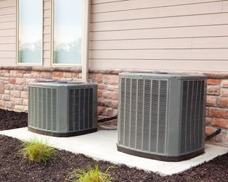 Two air conditioner units outside near window