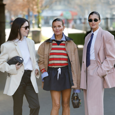 Annabel Rosendahl (L) wears white sweatshirt, cream blazer, black trousers, black and white zewbra print heels, Stella McCartney bag, Janka Polliani (C) wears blue striped shirt, beige and red striped Prada polo neck top, black mini skirt, beige jacket, Miu Miu bag, red heels, Darja Barannik (R) wears white shirt, blue tie, pink suit, outside Stella McCartney, during the Womenswear Fall/Winter 2025/2026 as part of Paris Fashion Week on March 05, 2025 in Paris, France.