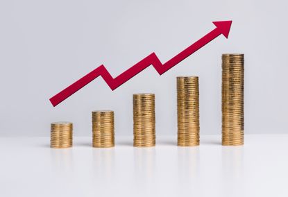 stacks of coins ascending in height, with a a red arrow going up