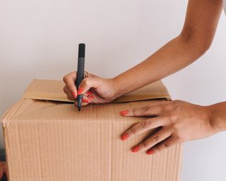 Woman labeling cardboard box