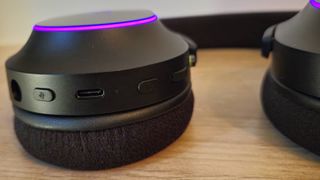 Image of the Razer Barracuda X Chroma gaming headset laying on a wooden countertop taken by author Rosalie Newcombe.