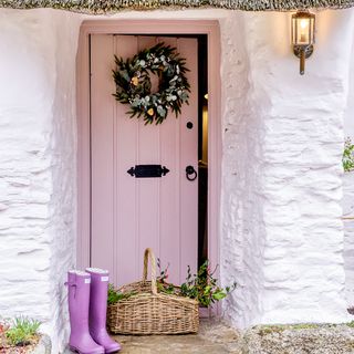 Entrance with pinnk front door and Christmas wreath