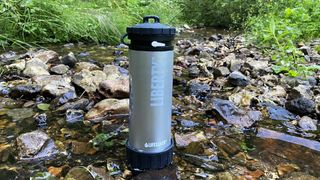 LifeSaver Liberty purifier in shallow stream with wet rocks in background