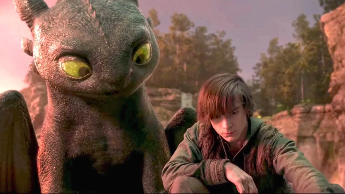 mason thames as hiccup beside CGI toothless in a cove in the 2025 how to train your dragon remake