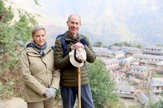 Prince Edward and Duchess Sophie hiking in Nepal standing and smiling at the camera with a city below them