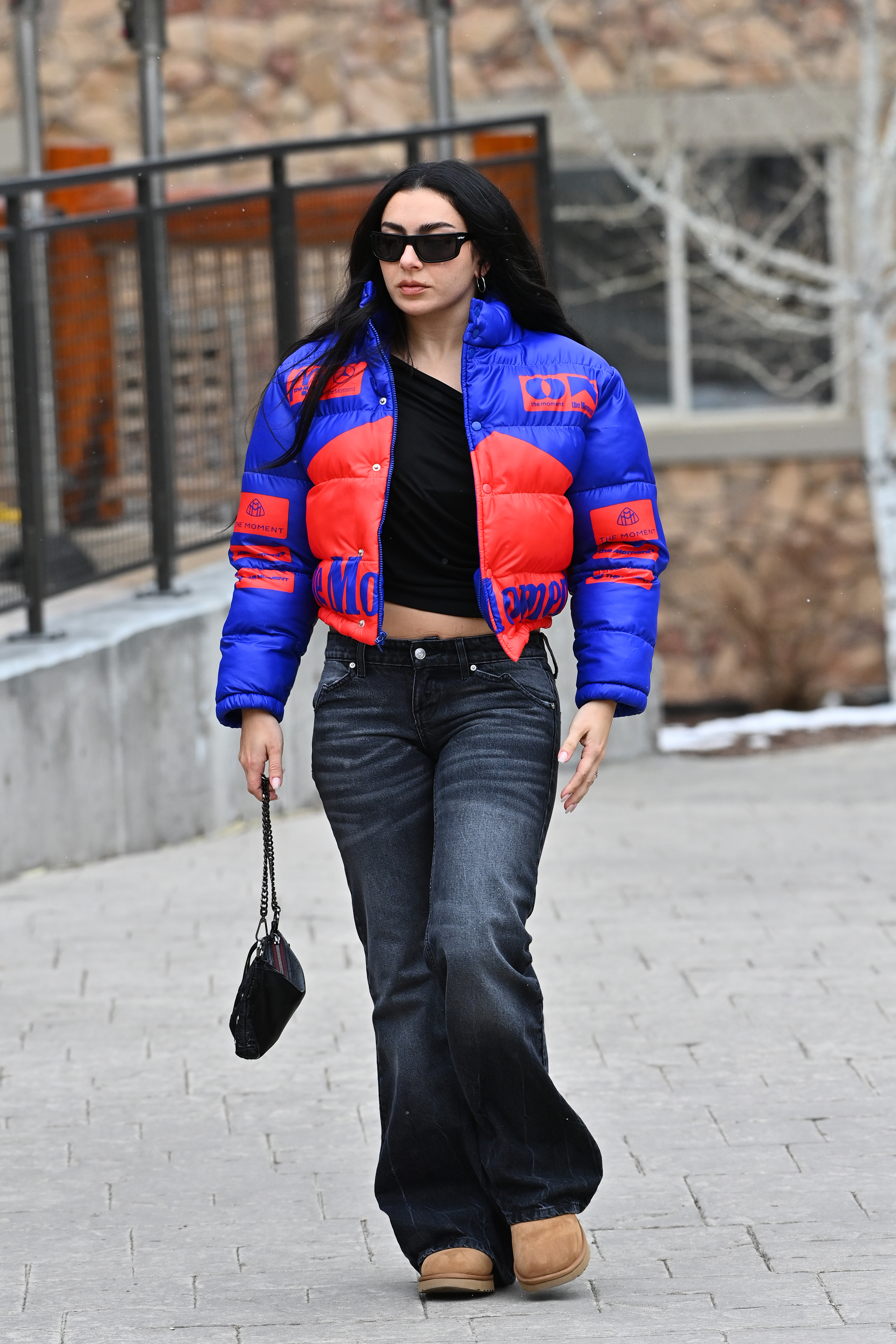 Charli XCX attending Sundance Film Festival wearing Saint Laurent, a puffer jacket, jeans, and Ugg boots