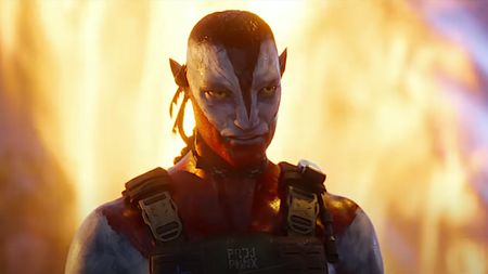 Na'vi character from Avatar: Fire and Ash wearing battle gear with flames surrounding