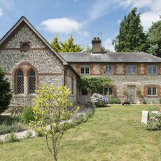 exterior of brick and flint house in hampshire with arched leaded windows