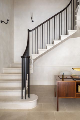 A white staircase with black banister